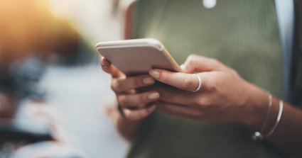 Person die ein Handy in der Hand hält