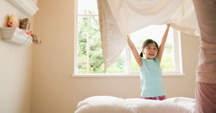 Kind freut sich an frischer Bettdecke